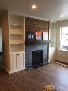 36 inch fireplace, stone veneer, custombuilt in cabinetry, alder mantel, barn wood above, and a tile woodplank floor