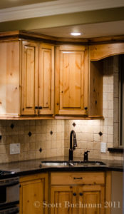 Travertine stone backsplash, knotty alder cabinets